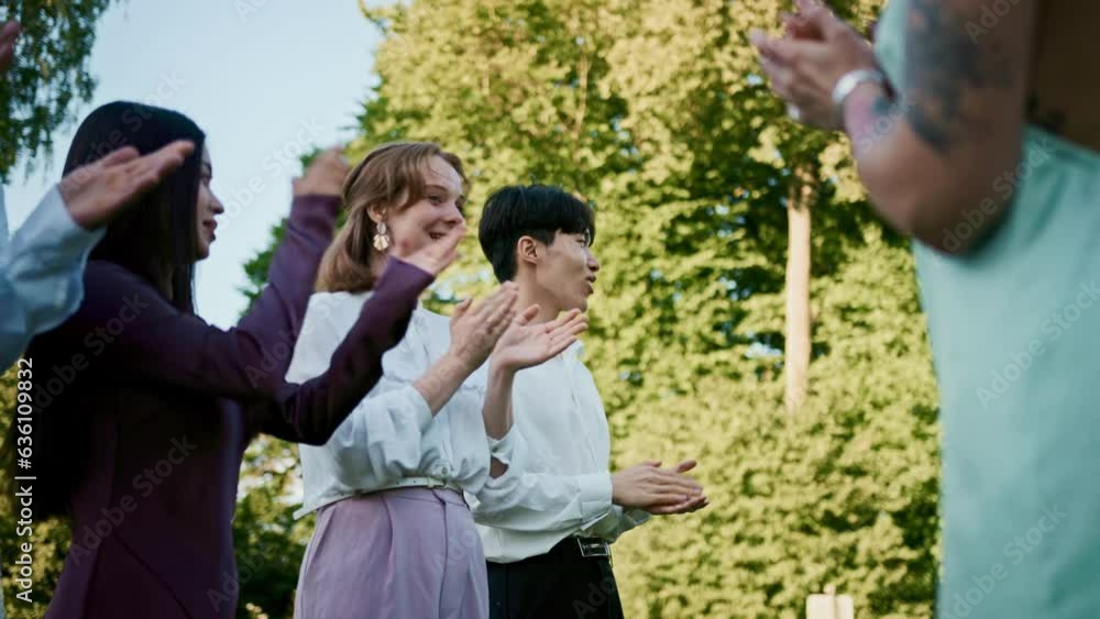 The groom walks past the applauding guests at an outdoor wedding The groom walks past the applauding guests at an outdoor wedding