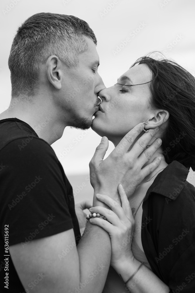 Fototapeta premium A young couple of beautiful people have fun in the field near round bales of dry hay
