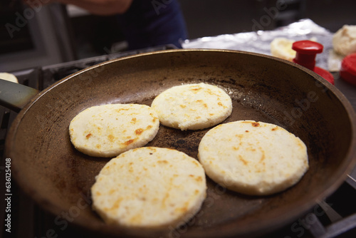 Portrait of a woman with a radiant, joyful smile as she makes arepas photo
