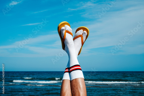 upside-down wearing socks and flip-flops on the beach photo