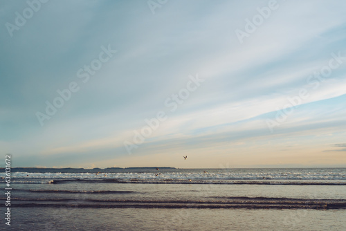 Golden hour seascape with gulls flying low over the waves photo