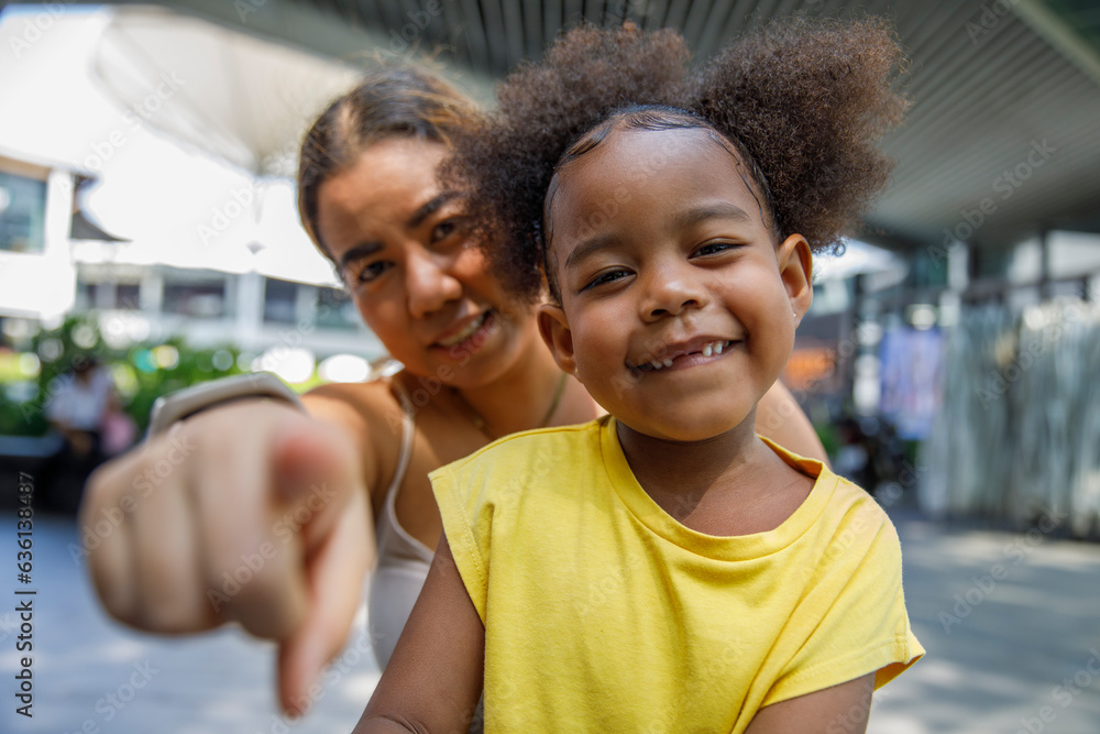 Cheerful mother with daughter pointing at the camera, pov Cheerful mother with daughter pointing at the camera, pov