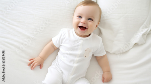 baby model wearing a blank empty white bodysuit, lying in a white bed, smiling