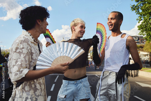 Three queer friends confidently walk down the street during gay pride photo