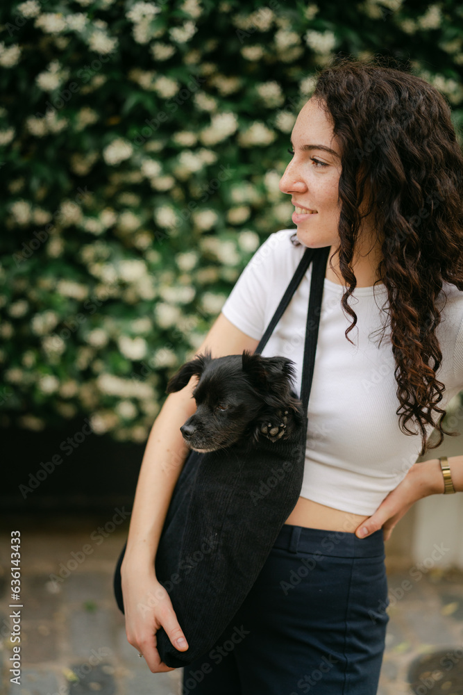 young woman snuggling her little black dog young woman snuggling her little black dog