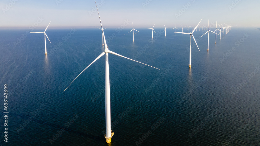 Windmill park with clouds and a blue sky, windmill park in the ocean aerial view with wind turbine Flevoland Netherlands Ijsselmeer. Green Energy production in the Netherlands Windmill park with clouds and a blue sky, windmill park in the ocean aerial view with wind turbine Flevoland Netherlands Ijsselmeer. Green Energy production in the Netherlands