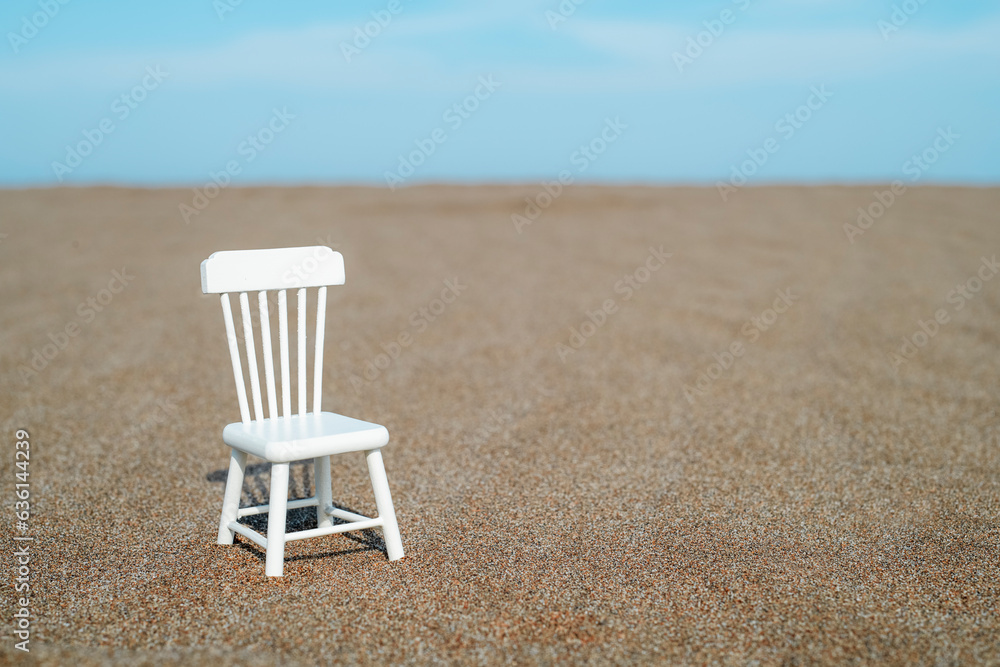 white toy chair on the sand white toy chair on the sand