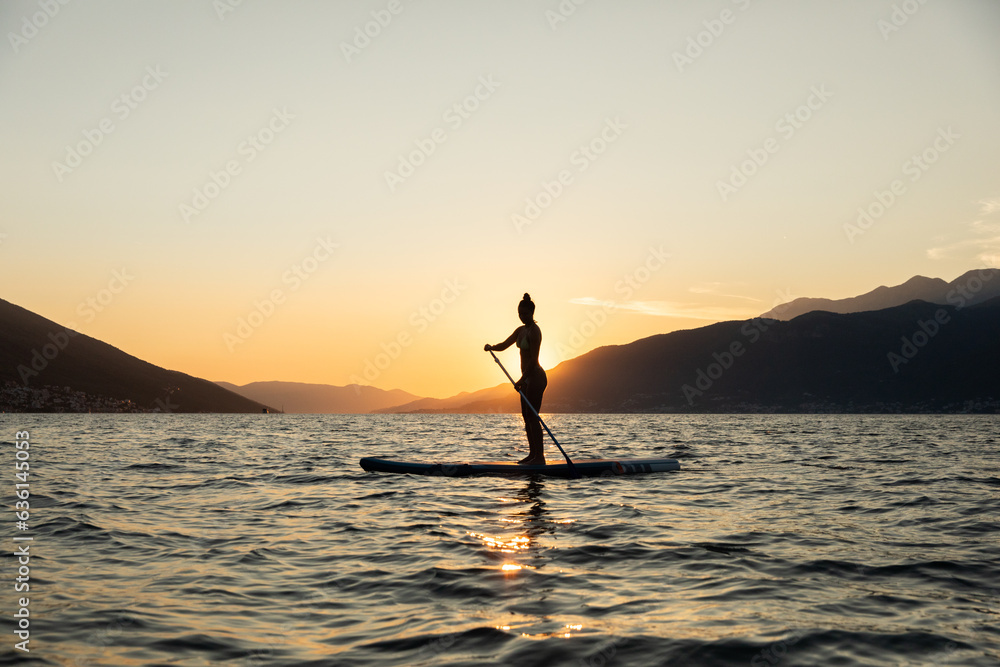 © Marko/Stocksy - Woman on SUP paddle board © Marko/Stocksy - Woman on SUP paddle board