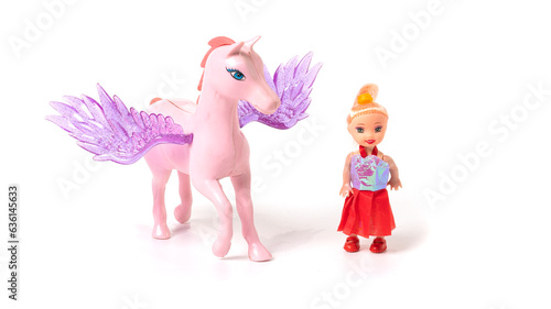 Plastic toy doll girl and unicorn isolated on white background
