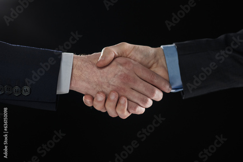 Men shaking hands. Confident businessman shaking hands on black background