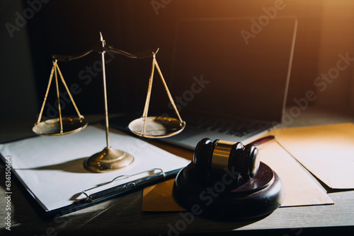 law legal technology concept. judge gavel on computer with scales of justice on desk of lawyer.