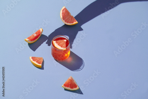 Glass of grapefruit juice and fresh citrus slices photo
