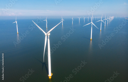 offshore windmill park with clouds and a blue sky, windmill park in the ocean aerial view with wind turbine Flevoland Netherlands Ijsselmeer. Green Energy in the Netherlands on a sunny day