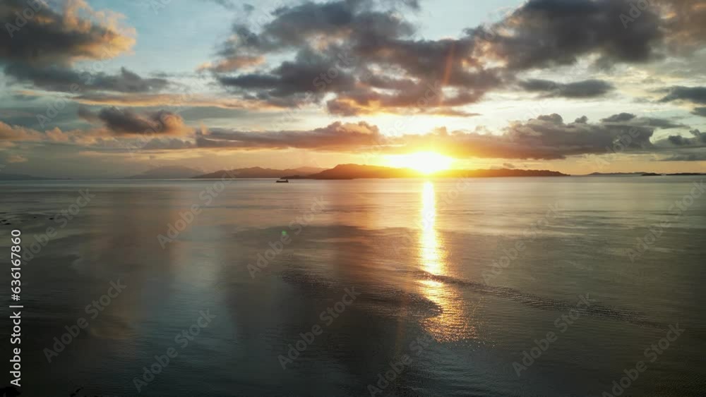 Setting sun flare ray spreads shining light across clouds and ocean, san andres catanduanes philippines, aerial Setting sun flare ray spreads shining light across clouds and ocean, san andres catanduanes philippines, aerial
