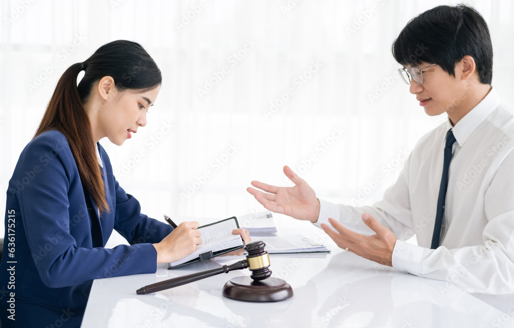 Attractive young lawyer in office Business man and lawyers discussing contract papers with brass scale on wooden desk in office. Law, legal services, advice, Justice and real estate concept. Attractive young lawyer in office Business man and lawyers discussing contract papers with brass scale on wooden desk in office. Law, legal services, advice, Justice and real estate concept.