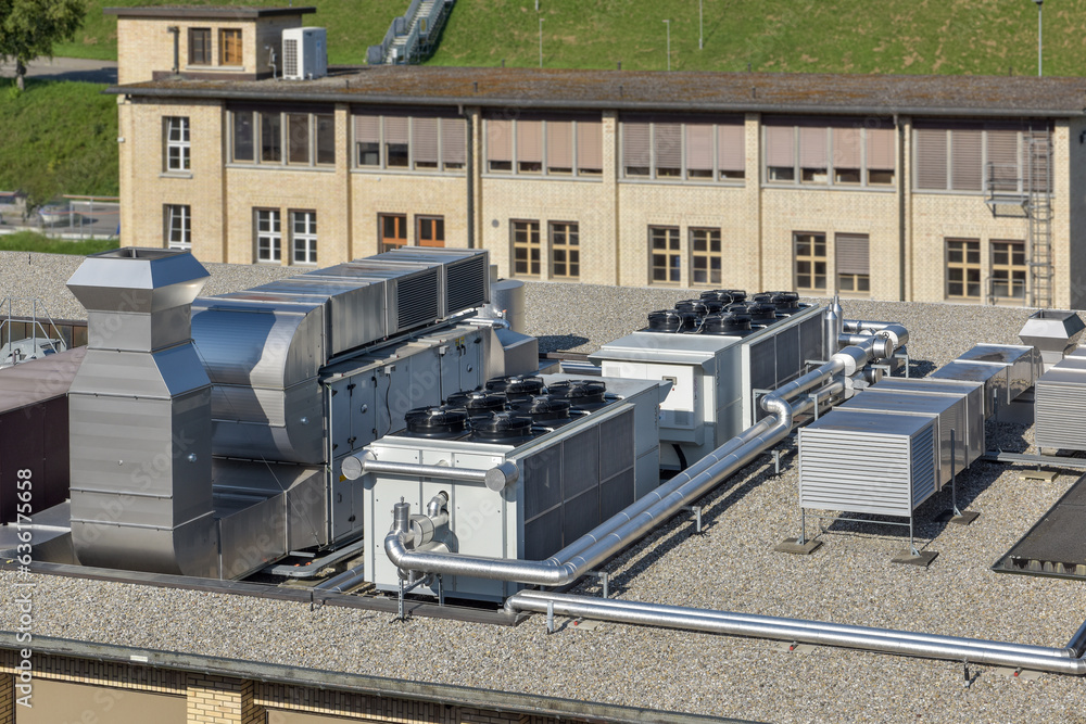 hvac ventilation system on a roof in front of a industrial building, chiller and cooler next to a monobloc