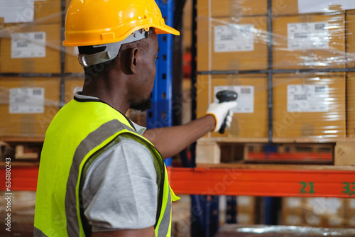 African american male worker factory holding a barcode scanner doing scan barcodes to count inventory in warehouse.