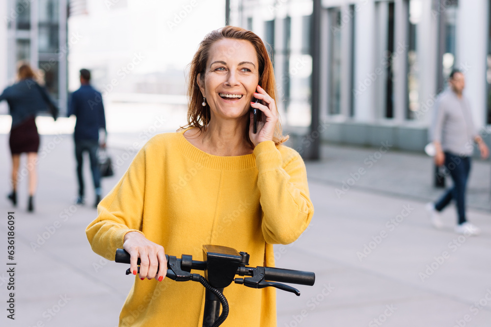 Fototapeta premium Active Senior Woman in the City: Phone Call and E-Scooter Ride