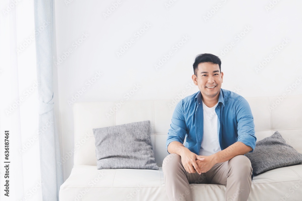 Portrait Asian man sitting on sofa