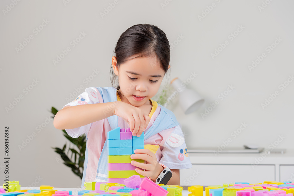 little girl is happy Playing colorful block puzzles. in the white room little girl is happy Playing colorful block puzzles. in the white room