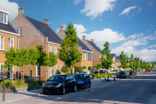 Wallpaper Mural Dutch Suburban area with modern family houses, newly built modern family homes in the Netherlands, nice and comfortable neighborhood. Some homes on the empty street in the suburbs of Urk Flevoland Torontodigital.ca