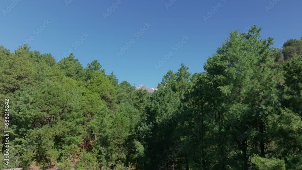 Drone rises above farmland fields to reveal epic iztaccihuatl on horizon, blue sky Drone rises above farmland fields to reveal epic iztaccihuatl on horizon, blue sky