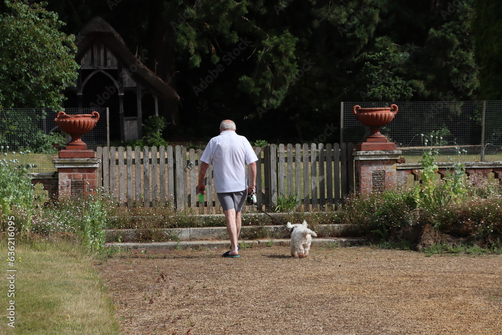 Man walking a dog in a garden in Sandringham, Norfolk, U.K.