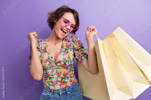 Photo of overjoyed cherful lovely girl fashionista buy trendy clothes special offer rejoice have fun isolated on purple color background photo