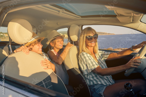 Mother driving a car with the two children in the back seats exp © ADDICTIVE STOCK CORE