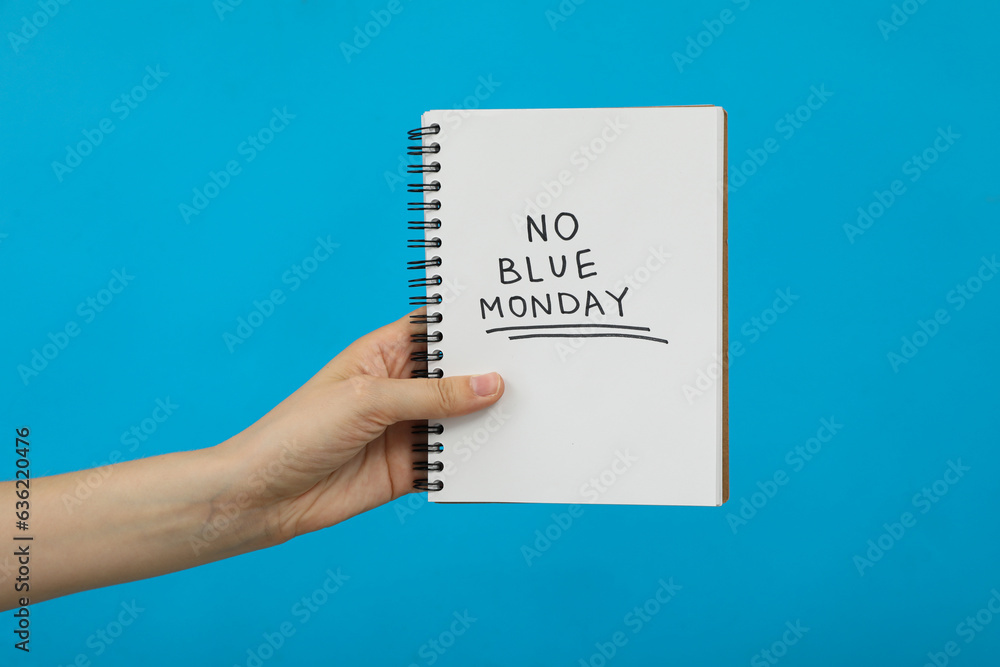 Notepad with text in hand on blue background Notepad with text in hand on blue background