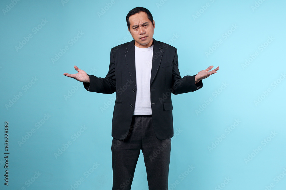 Portrait of asian man with clueless, ignorant, confused gestures, shrugging and stretching hands isolated on blue background Portrait of asian man with clueless, ignorant, confused gestures, shrugging and stretching hands isolated on blue background