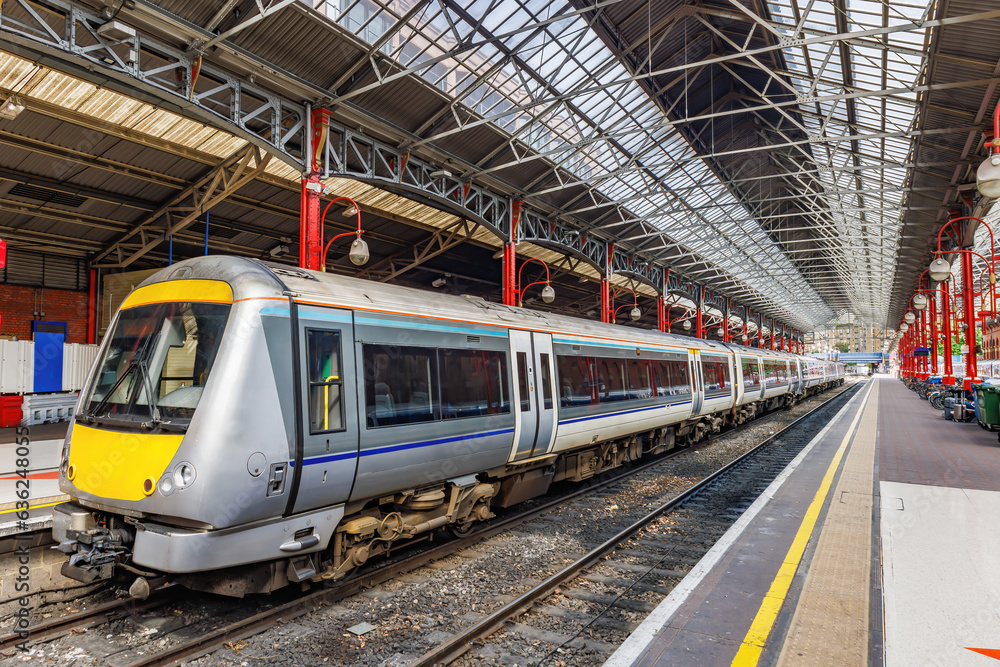 Naklejka premium A commuter train at the railway platform about to leave the station