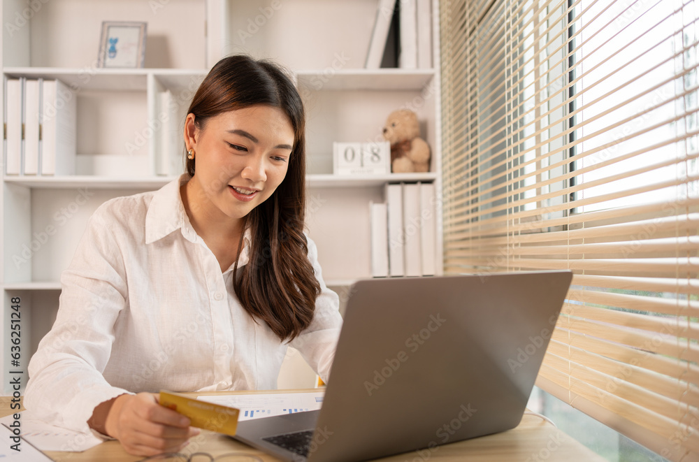 Woman's finger presses a keyboard and holds a credit card to register for payment or online transactions, Financial transactions and Internet security, Shopping online and banking online concept. Woman's finger presses a keyboard and holds a credit card to register for payment or online transactions, Financial transactions and Internet security, Shopping online and banking online concept.