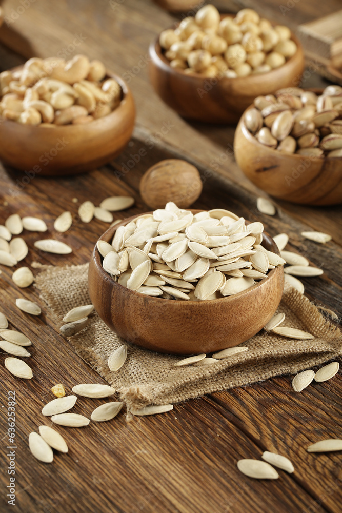 Fototapeta premium DRİED NUTS AND FRUİTS IN WOODEN BOWL ON BROWN FLOOR