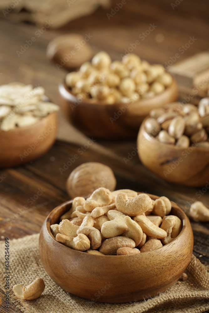 DRİED NUTS AND FRUİTS IN WOODEN BOWL ON BROWN FLOOR DRİED NUTS AND FRUİTS IN WOODEN BOWL ON BROWN FLOOR