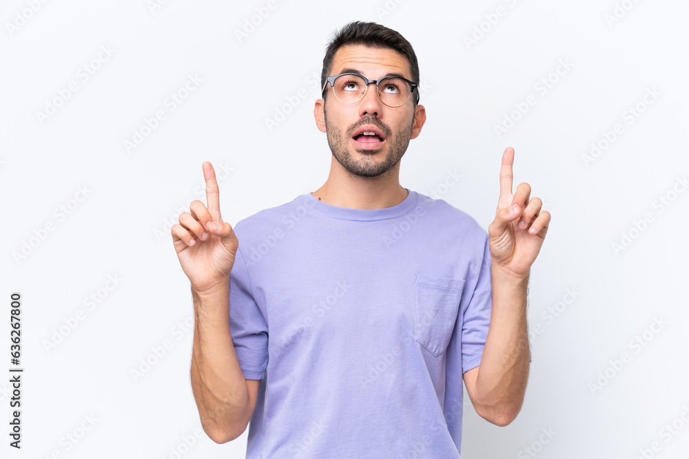 Young caucasian man isolated on white background surprised and pointing up Young caucasian man isolated on white background surprised and pointing up