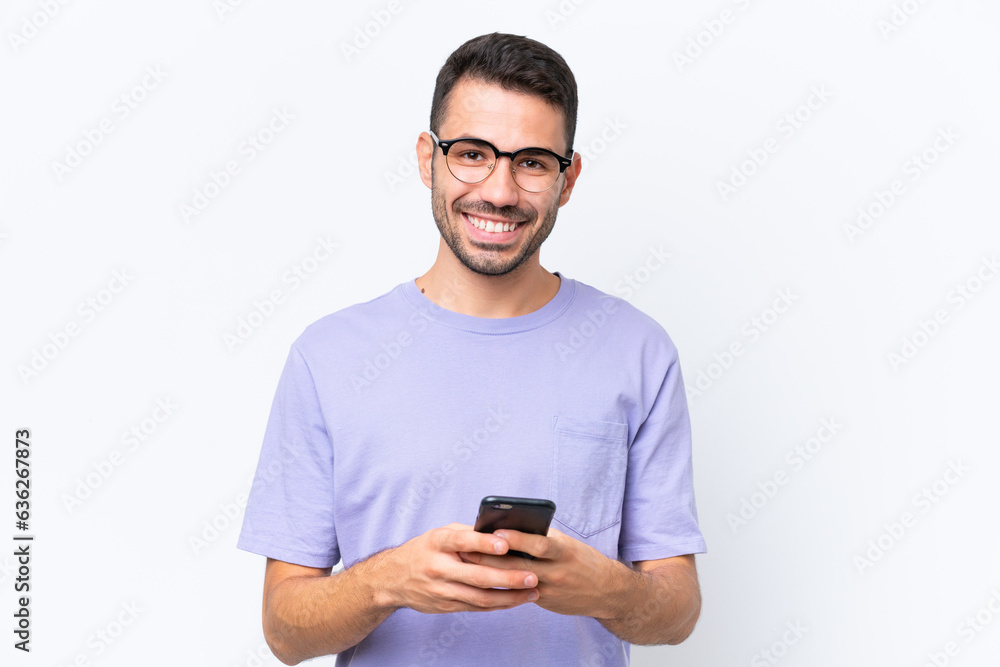 Young caucasian man isolated on white background sending a message with the mobile Young caucasian man isolated on white background sending a message with the mobile