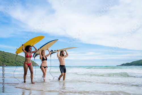 Group Friendship playing surfboard on the beach in weekend activity, Sport extreme healthy lifestyle concept.