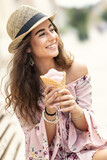 Portrait of a beautiful smiling lady in a summer outfit holding an ice cream on a hot summer day