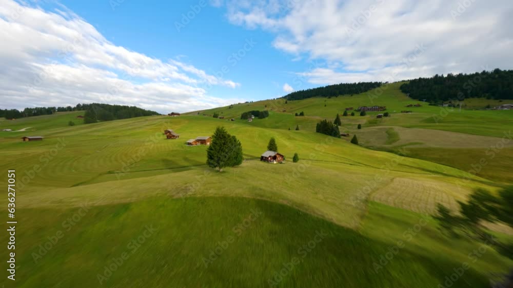 FPV drone flying above the cabins in Alpe di Siusi, Seiser Alm meadows at sunrise in the Dolomite mountains, Italian Alps. FPV drone flying above the cabins in Alpe di Siusi, Seiser Alm meadows at sunrise in the Dolomite mountains, Italian Alps.