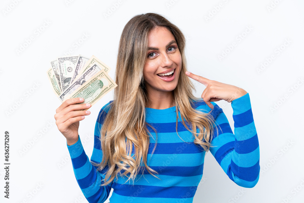 Young Uruguayan woman taking a lot of money isolated on white background giving a thumbs up gesture Young Uruguayan woman taking a lot of money isolated on white background giving a thumbs up gesture