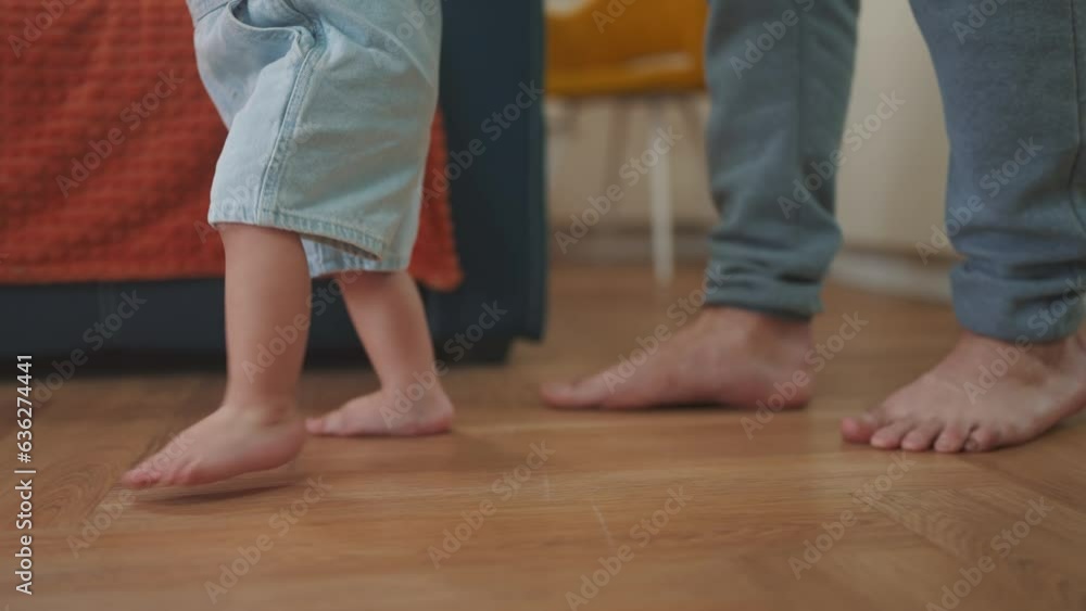 baby first steps. daddy a teaches baby toddler son to take first steps. happy family kid dream concept. baby indoors learning to walk father holding child hands. lifestyle fathers day concept baby first steps. daddy a teaches baby toddler son to take first steps. happy family kid dream concept. baby indoors learning to walk father holding child hands. lifestyle fathers day concept