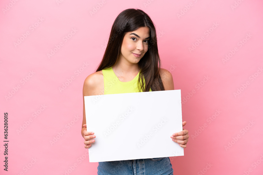 Young Brazilian woman isolated on pink background holding an empty placard Young Brazilian woman isolated on pink background holding an empty placard