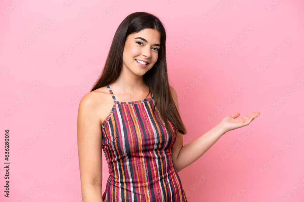 Young Brazilian woman isolated on pink background presenting an idea while looking smiling towards Young Brazilian woman isolated on pink background presenting an idea while looking smiling towards