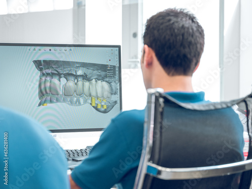 Fotografia Dentist working with digital teeth image in dental clinic