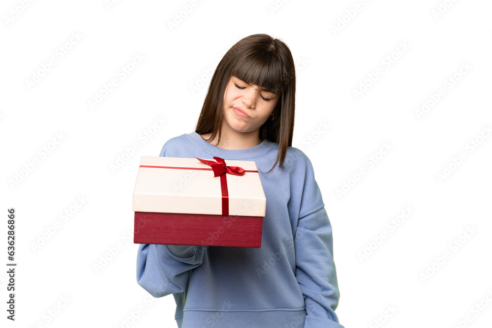 Little girl holding a gift over isolated chroma key background with sad expression Little girl holding a gift over isolated chroma key background with sad expression