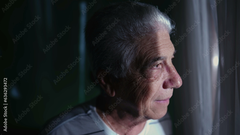 Elderly Gray-Hair Man Standing at Home Window, Watching Neighborhood with Contemplative Expression