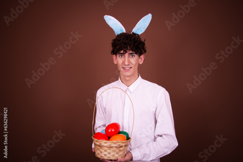 Easter. Young attractive guy posing with easter eggs in bunny ears.