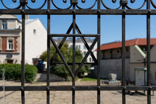 Star of David on metal fence outside synagogue on Szeroka street in Krakow, Poland. Symbol of Jewish identity and Judaism. Historic Jewish Quarter Kazimierz district of old town Kraków.