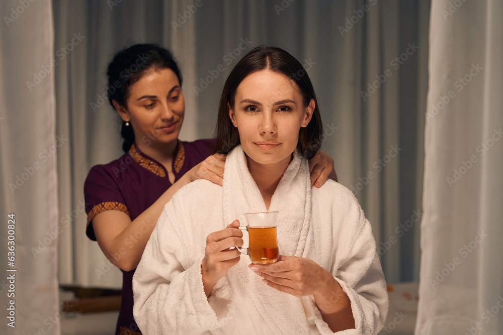 Young woman undergoing Thai massotherapy session at beauty clinic Young woman undergoing Thai massotherapy session at beauty clinic